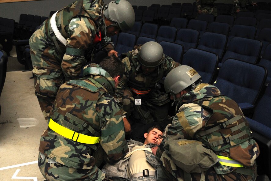 Airmen part of the personnel deployment readiness function shelter management team aid a role player at the base theater during exercise Beverly Midnight 14-01 at Kunsan Air Base, Republic of Korea, Feb. 7, 2014. While Airmen provided care, a wing inspection team member observed to ensure proper procedures were implemented. (U.S. Air Force photo by Staff Sgt. Jessica Haas/Released)