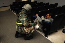Tech. Sgt. Richard Moss, 8th Comptroller Squadron budget technician, performs self-aid and buddy care on an exercise role player during exercise Beverly Midnight 14-01 at the base theater on Kunsan Air Base, Republic of Korea, Feb. 7, 2014. This scenario allowed the Wolf Pack to demonstrate their ability to respond to a mass casualty situation and aid Airmen needing medical attention. (U.S. Air Force photo by Staff Sgt. Jessica Haas/Released) 