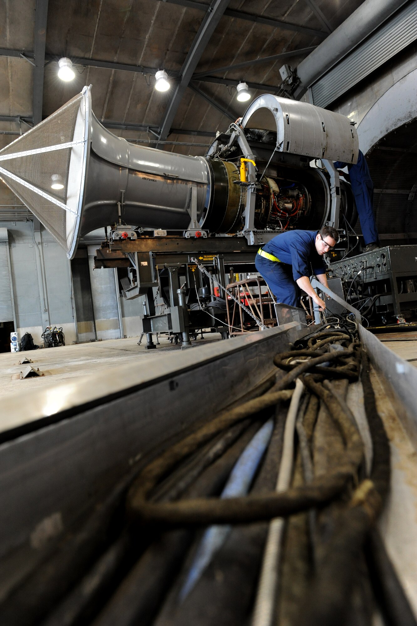U.S. Air Force Staff Sgt. Benjamin Laravie, 18th Component Maintenance Squadron test cell aerospace propulsion craftsman (left) and Senior Airman Andre Ingram, 18th CMS test cell aerospace propulsion journeyman, pull and attach cables to a TF-34 engine on Kadena Air Base, Japan, Feb. 5, 2014. Members of the test cell support the 51st Fighter Wing A-10 Thunderbolt II from Osan Air Base, Republic of Korea, by running a series of tests in the hush house. The tests simulate aircraft limits in air, checking for safety and serviceability. (U.S. Air Force photo by Airman 1st Class Keith James)