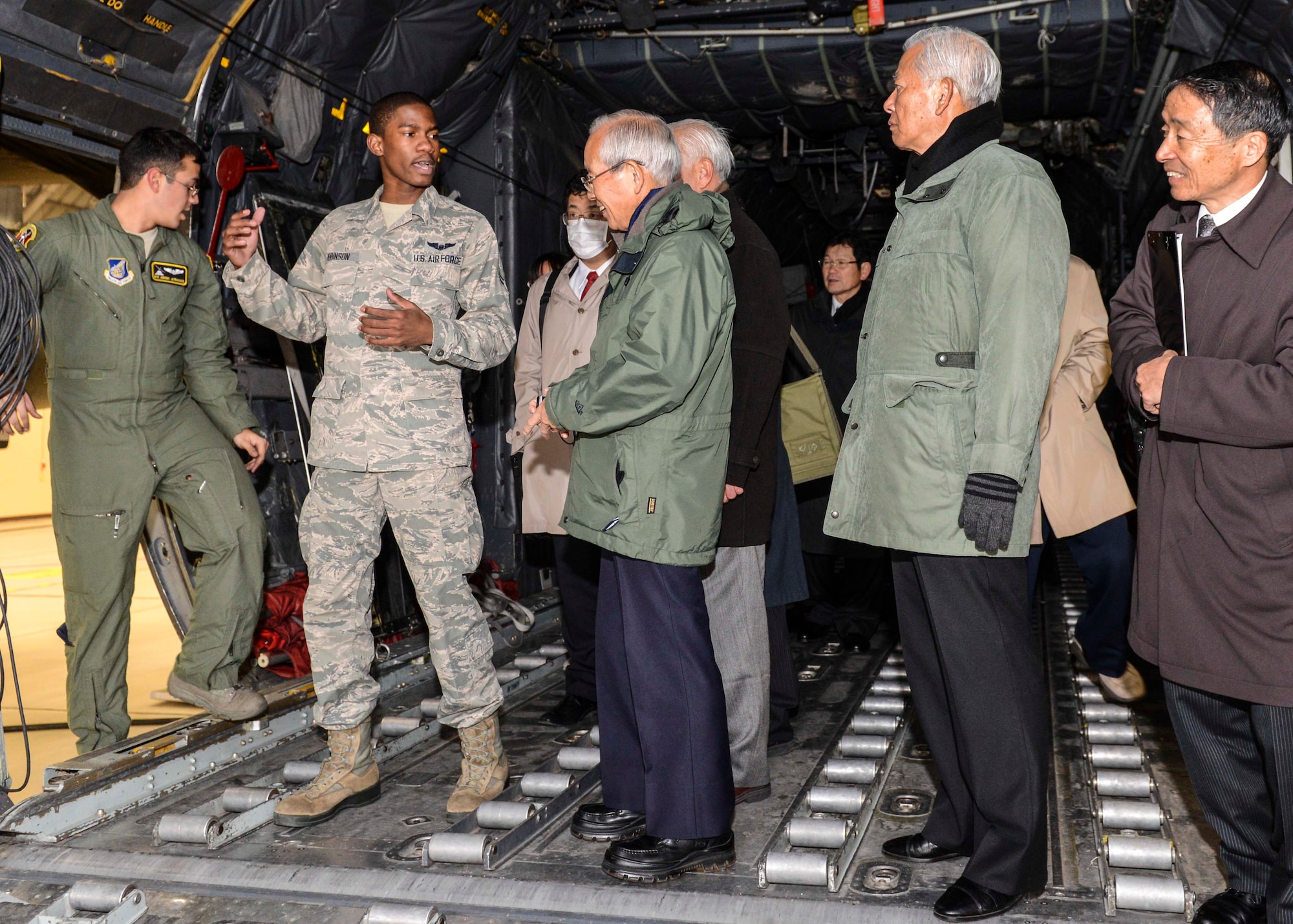 Airman 1st Class Adrian Robinson, 36th Airlift Squadron loadmaster, explains many functions in a C-130 to members of the Japan Society for Security and Crisis Management at Yokota Air Base, Japan, Feb. 4, 2014.  Japan Society members toured the inside of a C-130, the main fire department and the emergency operation center.  (U.S. Air Force photo by Airman 1st Class Soo C. Kim / released)
