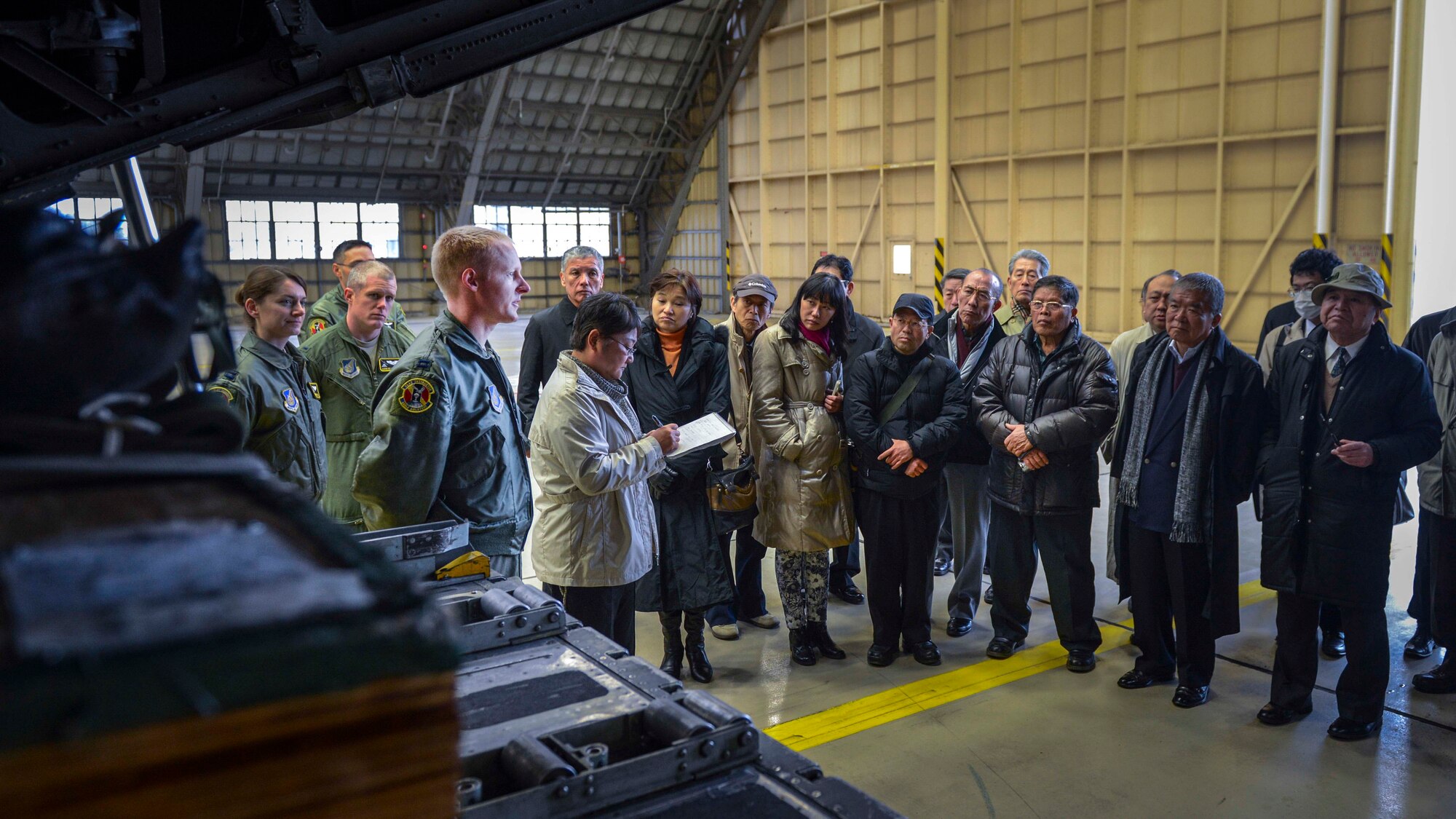 Capt. Olin Johnson, 36th Airlift Squadron C-130 evaluator navigator, explains the advantages of Low-Cost, Low Altitude to members of the Japan Society for Security and Crisis Management at Yokota Air Base, Japan, Feb. 4, 2014.  The Japan Society member’s visit allowed Yokota to demonstrate its disaster response capability.  (U.S. Air Force photo by Airman 1st Class Soo C. Kim / released)