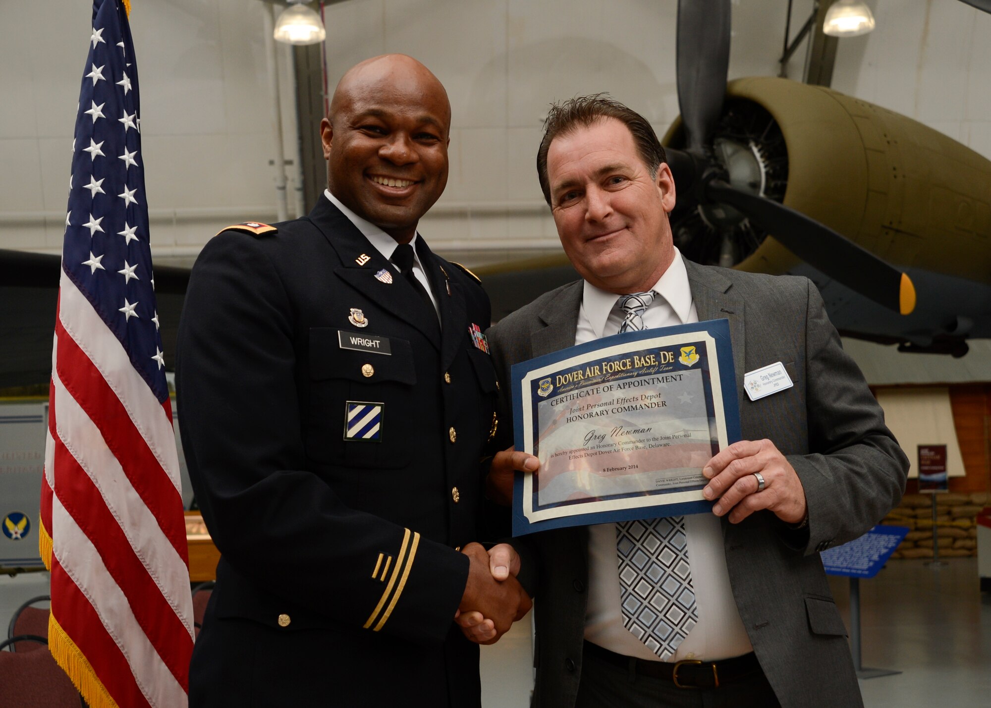 Lt. Col. Davie Wright, commander of the Joint Personal Effects Depot, presents Greg Newman, facility manager specialist form Hillyard Industries, Inc., with a certificate during the 2014 Honorary Commander Induction Ceremony, Feb. 8, 2014, at the Air Mobility Command Museum, Dover Air Force Base, Del. Honorary commanders are partnered with base senior leadership from the 436th Airlift Wing, 512th Airlift Wing, Air Force Mortuary Affairs Operations Center, Armed Forces Medical Examiner System, Joint Personal Effects Depot, and the 373rd Training Squadron Detachment 3. (U.S. Air Force photo/Staff Sgt. Elizabeth Morris)