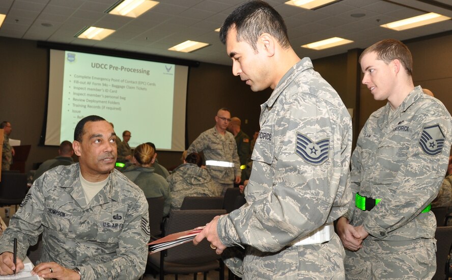 Tech. Sergeant Van Thompson, NCOIC of food services, takes names and checks his list as he distrubutes a meal-ready-to-eat (MRE) meal ready to eat to Tech. Sergeant Robert Zuniga, and other personnel during a 932nd Airlift Wing training exercise.   (U.S. Air Force photo/Staff Sergeant Amber Hodges)