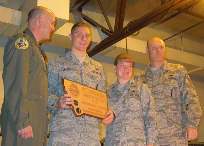 120th Security Forces Senior Airman Merrill Jessop holds his 2014 Montana Air National Guard Airman of the Year plaque during the 120th Fighter Wing awards ceremony held during the January unit training assembly. 120th Fighter Wing Commander Col. J. Peter Hronek, 120th Fighter Wing Vice Commander Col. Donna Loomis, and 120th Fighter Wing Command Chief Master Sgt. Timothy Huffman look on. National Guard photo/Senior Master Sgt. Eric Peterson.