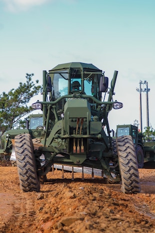 Cpl. Sal J. Flores drives a 120M motorized road grader Jan. 28 at Range 16 on Camp Hansen. Flores is a combat engineer with heavy equipment platoon, Support Company, 9th Engineer Support Battalion, 3rd Marine Logistics Group, III Marine Expeditionary Force. 

