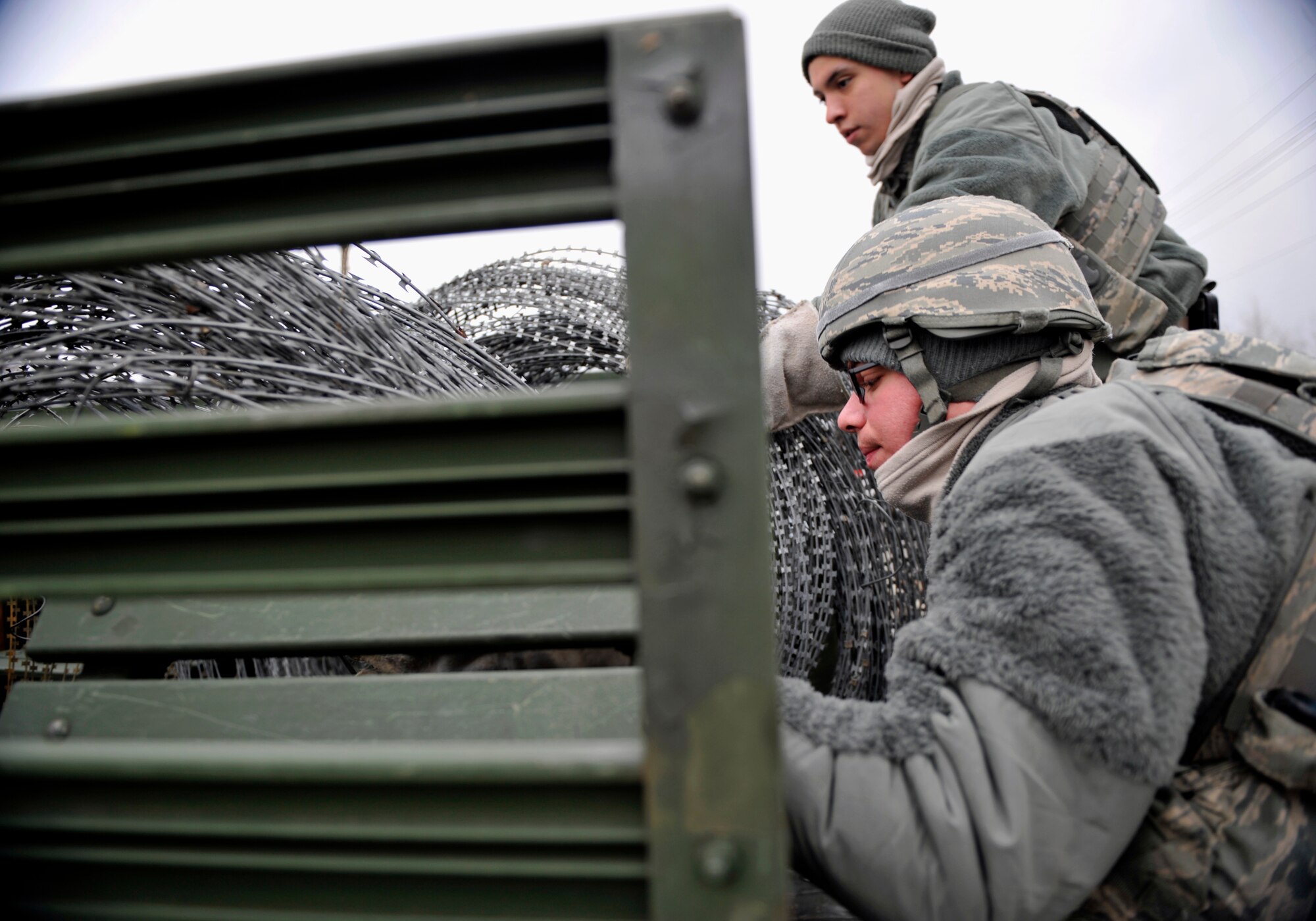Members of the 51st Security Forces Squadron prepare to unload concertina wire from the bed of a truck to use as a barrier during Operational Readiness Exercise Beverly Midnight 14-02 at Osan Air Base, Republic of Korea, Feb. 9, 2014. During exercises and war-time contingency operations, c-wire is placed strategically around the base. (U.S. Air Force photo/Senior Airman Siuta B. Ika)