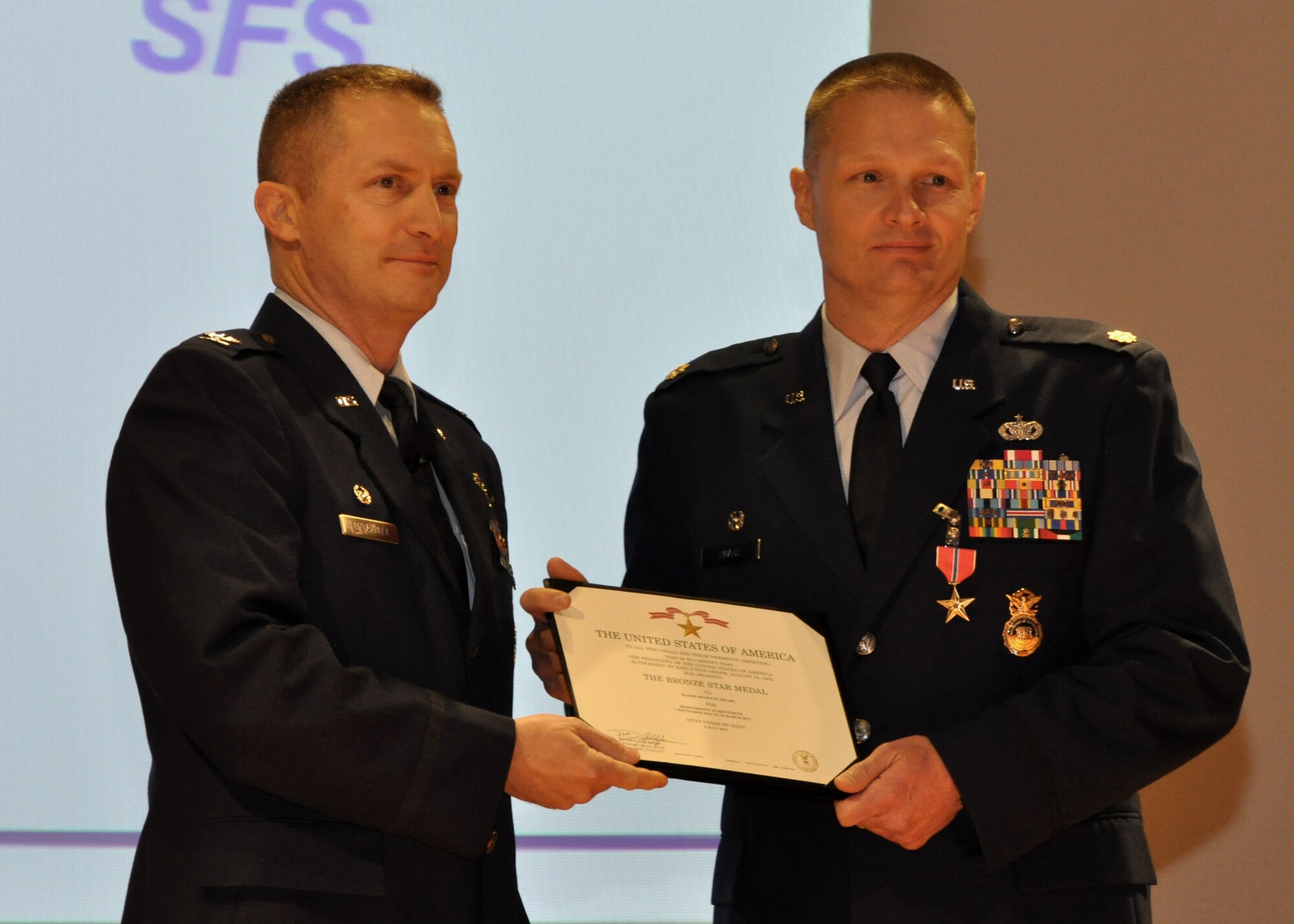 Col. James Fontanella stands with Bronze Star recipient Maj. Shawn Swarz Feb. 9, at the Joint Base Charleston theater. While deployed, Swarz served as the operations officer for the 455th Expeditionary Security Forces Group, 455th Air Expeditionary Wing Bagram Airfield Afghanistan. Swarz was awarded the Bronze Star for his leadership and involvement while engaged in ground operations in and around Bagram Airfield, Afghanistan from Sept. 1 to March 10, 2013. The Bronze Star is the fourth highest combat decoration a military member can receive for heroism, bravery or meritorious service. Fontanella is the 315th Airlift Wing commander, and Swarz is the 315 AW Security Forces Squadron commander. (U.S. Air Force photo/Senior Airmen Meredith Thomas)