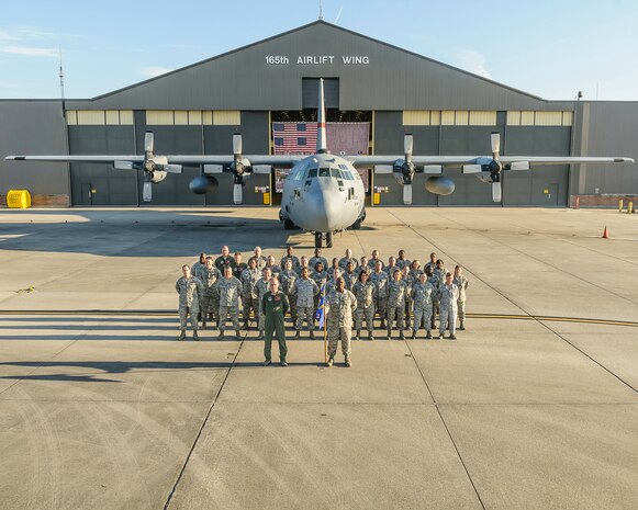 Members of the 165th Medical Group stand in front of a C-130H Hercules, Sept. 16, 2012 at Savannah Air National Guard base in Garden City, Ga. U.S. Air Force Col. Patrick Morgan, 165th Medical Group Commander stands in front with Master Sgt. Brian Duncan 165th Medical Group First Sergeant holding the guidon. (U.S. Air National Guard photo by Tech. Sgt. Delano/released)