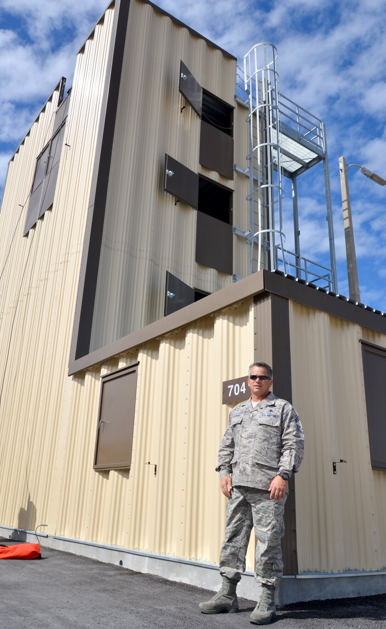 Chief Master Sgt. Doug Kestranek, 308th Rescue Squadron chief enlisted manager, stands in front of the Guardian Angel Training Tower at the 920th Rescue Wing, Patrick Air Force Base, Fla. The tower is specifically designed to prepare them for the battlefield by simulating a variety of rescue environments. (U.S. Air Force photo/2nd Lt. Leslie Forshaw)