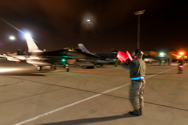 U.S. Air Force Senior Airman Ty McNew ,140th Maintenance Squadron, Colorado Air National Guard, ushers out an F-16 Fighting Falcon fighter jet from the 120th Fighter Squadron at Buckley Air Force Base, Colo., during a night training mission at Red Flag 14-1, at Nellis Air Force Base, Nev., Feb. 04, 2014. Combat units come together from the United States and its allied countries to engage in realistic combat training scenarios within Nellis’ 2.9 million acre Test and Training Range Complex. (U.S. Air National Guard photo/Tech. Sgt. Wolfram M. Stumpf)