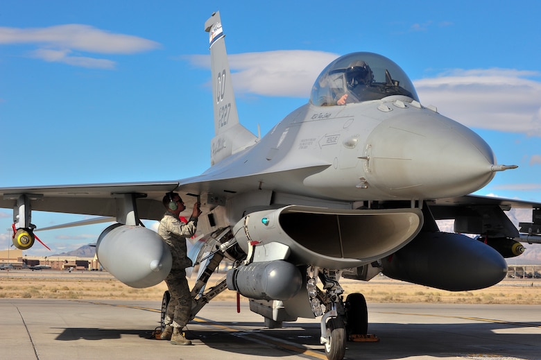 U.S. Air Force Tech. Sgt. Jacob Adams, 140th Maintenance Squadron, Colorado Air National Guard, performs final checks on an F-16 Falcon fighter jet from the 120th Fighter Squadron at Buckley Air Force Base, Colo., before a training mission at Red Flag 14-1, at Nellis Air Force Base, Nev., Jan. 31, 2014. Combat units come together from the United States and its allied countries to engage in realistic combat training scenarios within Nellis’ 2.9 million acre Test and Training Range Complex. (U.S. Air National Guard photo/Tech. Sgt. Wolfram M. Stumpf)