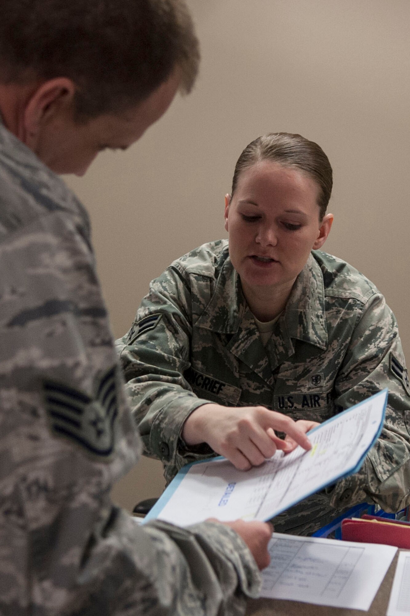 U.S. Air Force Airman 1st Class Annalisa Moncrief, 307th Medical Squadron technician, directs a patient to the next location during his physical process at Barksdale Air Force Base, La., Feb.8, 2014. The squadron processes and updates medical records for more than a hundred patients during each Unit Training Assembly weekend. (U.S. Air Force photo by Master Sgt. Jeff Walston/Released) 