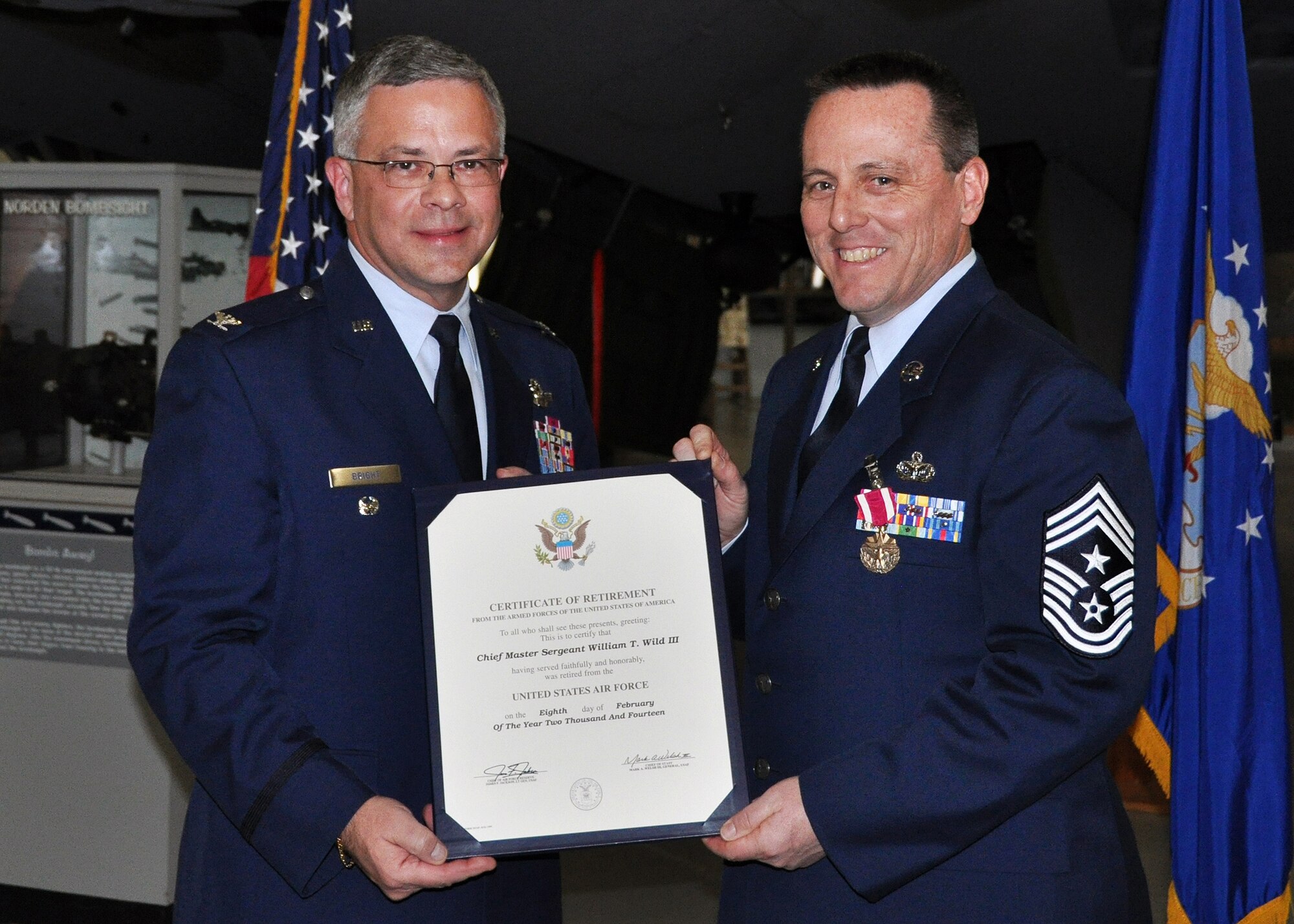 Col. Randal L. Bright, Air Force Reserve Command, Robins Air Force Base, Ga., presents 512th Airlift Wing Command Chief Master Sgt. William T. Wild III with his certificate of retirement during Wild's official retirement ceremony at the Air Mobility Command Museum, Dover, Del., Feb. 8, 2014. Wild retires with almost 29 years of service to the Air Force. (U.S. Air Force photo/Senior Airman Erika Brooke)