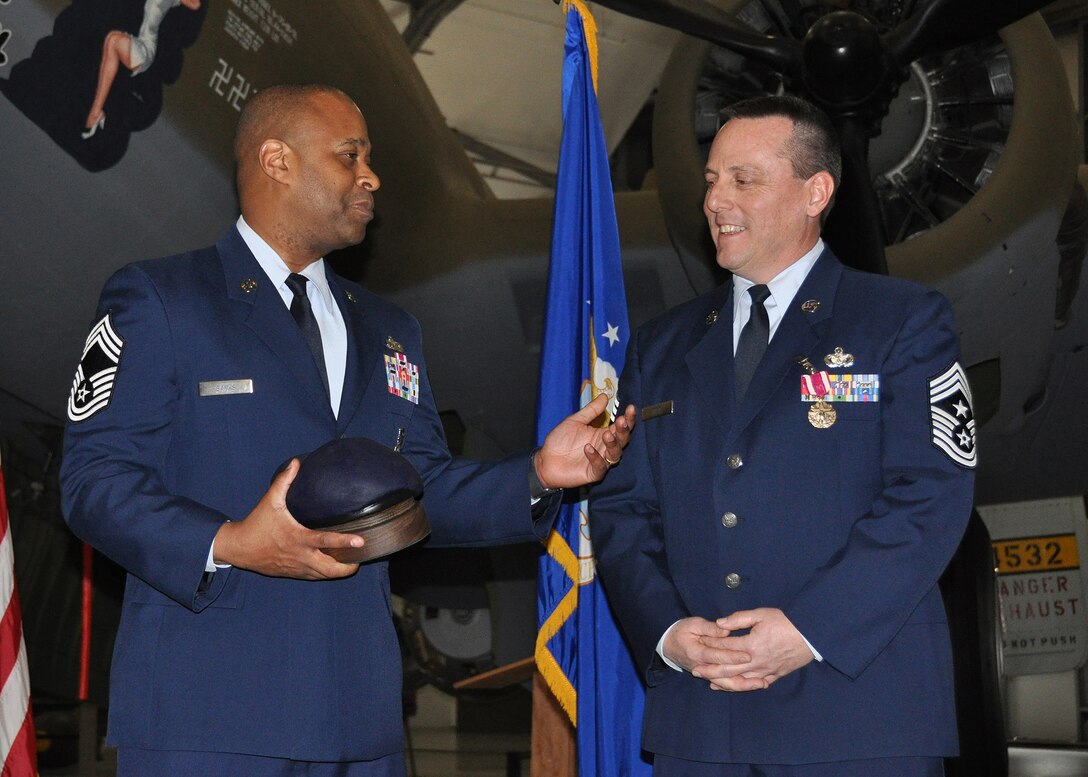 Chief Master Sgt. Mark Banks, 512th Security Forces squadron, presents 512th Airlift Wing Command Chief Master Sgt. William T. Wild III with a token of appreciation and remembrance during Wild's official retirement ceremony at the Air Mobility Command Museum, Dover, Del., Feb. 8, 2014. (U.S. Air Force photo/Senior Airman Erika Brooke)
