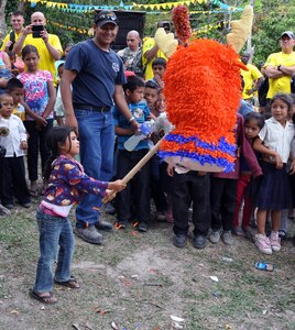 A young Honduran girl takes a swing at a pinata during the 52nd Joint Task Force-Bravo "Chapel Hike" in Honduras, Feb. 8, 2014.  More than 120 members of Joint Task Force-Bravo spent the day delivering more than 2,400 pounds of food and medical supplies to families in need in the mountain village of La Laguna, Honduras.  To deliver the supplies, Task Force members carried the items on a more than seven-mile round trip hike, with an elevation gain of 1,700 feet.  All of the food and supplies were purchased with funds donated by Task Force members.  (U.S. Air Force photo by Capt. Zach Anderson)  