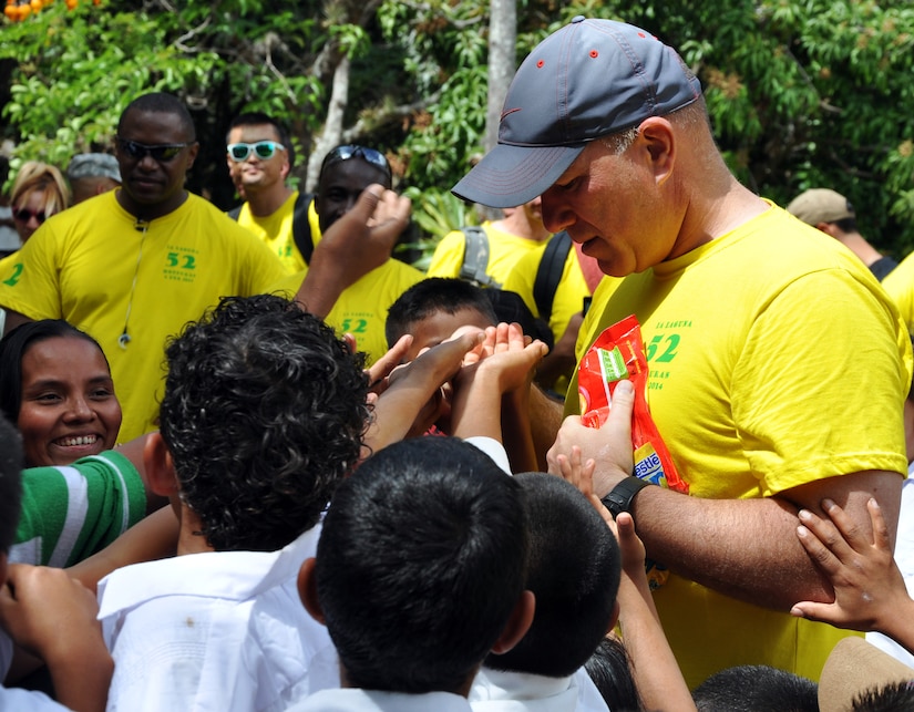 U.S. Army Col. Thomas Boccardi, Joint Task Force-Bravo Commander, hands out candy to Honduran children during the 52nd Joint Task Force-Bravo "Chapel Hike" in Honduras, Feb. 8, 2014.  More than 120 members of Joint Task Force-Bravo spent the day delivering more than 2,400 pounds of food and medical supplies to families in need in the mountain village of La Laguna, Honduras.  To deliver the supplies, Task Force members carried the items on a more than seven-mile round trip hike, with an elevation gain of 1,700 feet.  All of the food and supplies were purchased with funds donated by Task Force members.  (U.S. Air Force photo by Capt. Zach Anderson)  