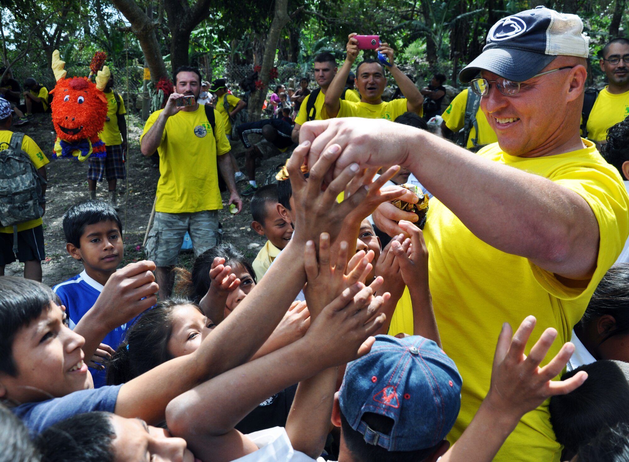 U.S. Army Col. John Sena, Soto Cano Air Base Army Support Activity Commander, hands out candy to Honduran children during the 52nd Joint Task Force-Bravo "Chapel Hike" in Honduras, Feb. 8, 2014.  More than 120 members of Joint Task Force-Bravo spent the day delivering more than 2,400 pounds of food and medical supplies to families in need in the mountain village of La Laguna, Honduras.  To deliver the supplies, Task Force members carried the items on a more than seven-mile round trip hike, with an elevation gain of 1,700 feet.  All of the food and supplies were purchased with funds donated by Task Force members.  (U.S. Air Force photo by Capt. Zach Anderson)  