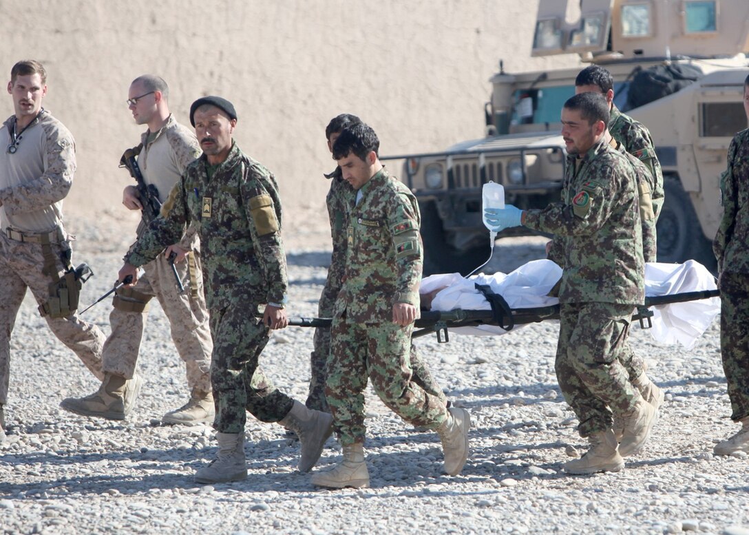 Marines and sailors with Security Force Assistance Advisor Team 2-215 and soldiers with Afghan National Security Forces carry a casualty during a medical evacuation on an Afghan National Army base in the Sangin Valley, Helmand province, Afghanistan, Jan. 28, 2014. The soldier sustained wounds from an improvised explosive device blast during an operation to clear the Sangin Valley of threats to the local populace prior to the April 5 Afghanistan presidential election. (Marine Corps photo by Cpl. Joshua Young)