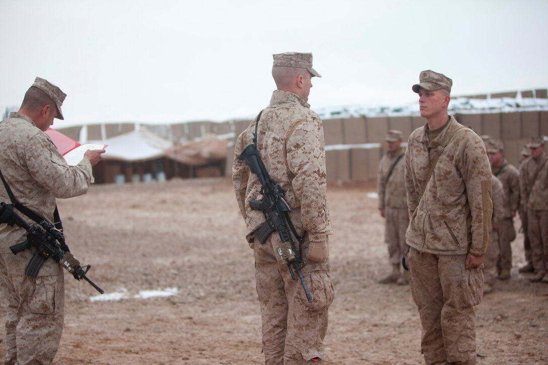 Lance Cpl. Paul Guerrieri, right, an infantryman with Charlie Company, 1st Battalion, 9th Marine Regiment, Regional Command (Southwest), stands at attention during an award ceremony aboard Patrol Base Boldak in Helmand province, Afghanistan, Feb. 4, 2014. Guerrieri received the Navy and Marine Corps Achievement Medal for being personally responsible for the operational readiness and daily functioning of the patrol base and displaying superior performance of his duties while serving in the billet of police sergeant. (U.S. Marine Corps photo by Cpl. Cody Haas/ Released)