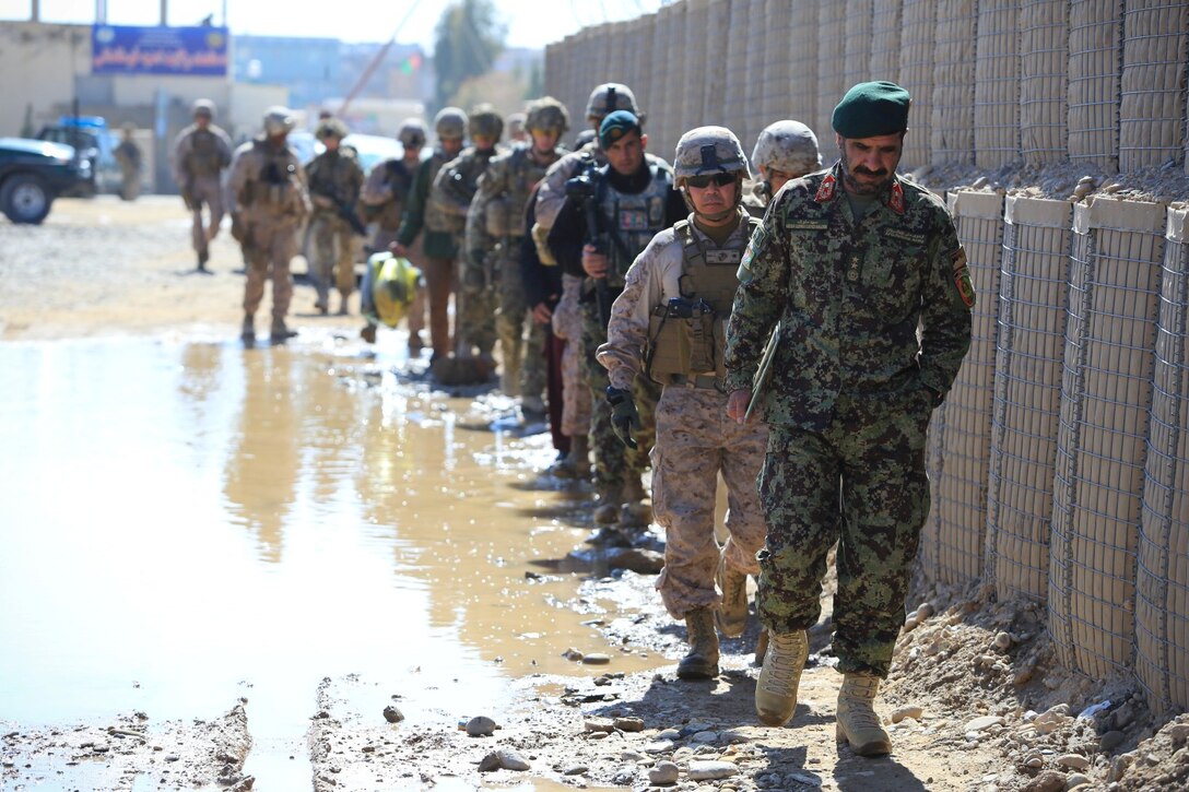 Afghan National Army (ANA) Maj. Gen. Sayed Malook, Commander of Afghanistan's 215th Corps, followed by U.S. Marine Corps Brig. Gen. Daniel D. Yoo, Commander of Regional Command (Southwest) and International Security Assistance Force (ISAF) personnel walk down a street in Lashkar Gah, Helmand province, Afghanistan, Feb. 10, 2014. Malook, Yoo and ISAF personnel attended an Afghan leadership meeting also known as a “Shura” regarding military affairs in the local region. (Official U.S. Marine Corps photo by Lance Cpl. Darien J. Bjornda/Releasedl)