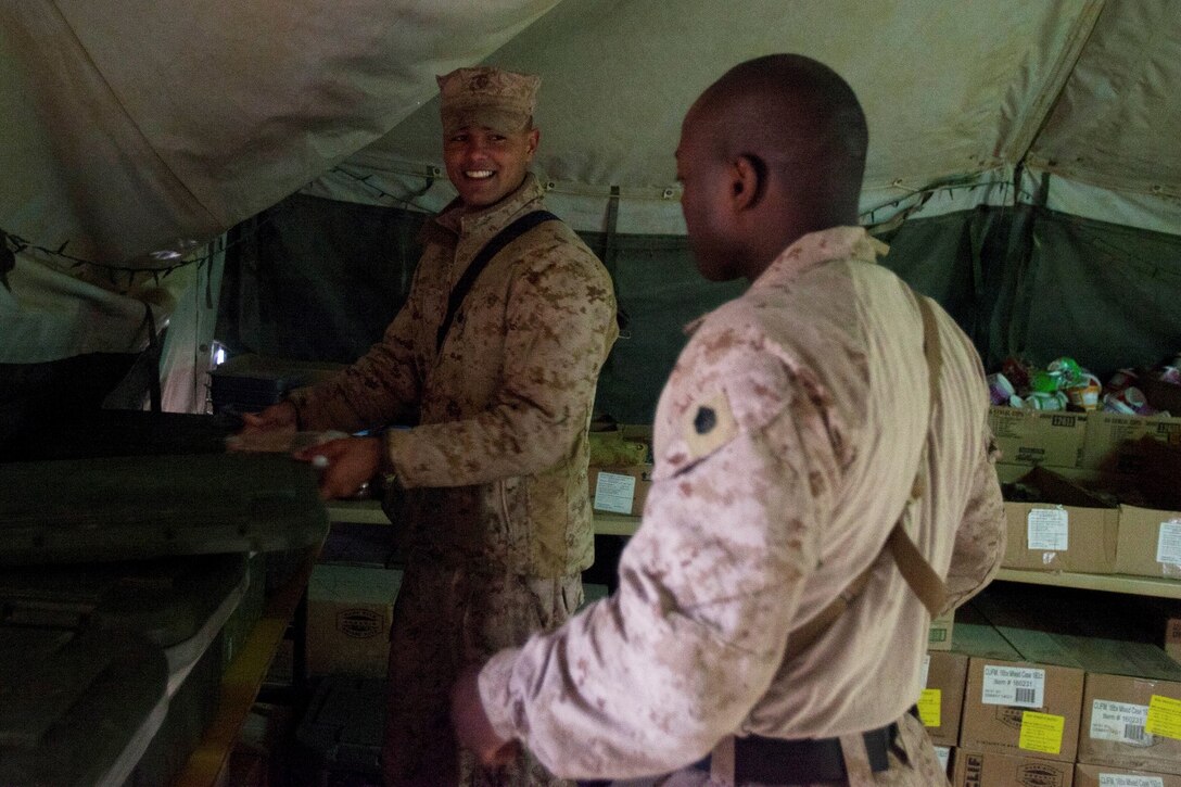 Sergeant Marcus Myers, left, a food service specialist with Headquarters Company, 1st Battalion, 9th Marine Regiment, Regional Command (Southwest), and Staff Sgt. Aviel Smith, right, food service specialist chief, Headquarters Co., prepare a meal for troops aboard Patrol Base Boldak in Helmand province, Afghanistan, Feb. 2, 2014. Myers was meritoriously promoted to the rank of sergeant and received a Navy and Marine Corps Achievement Medal after his outstanding service was recognized by Gen. James F. Amos, commandant of the Marine Corps. (U.S. Marine Corps photo by Cpl. Cody Haas/ Released)
