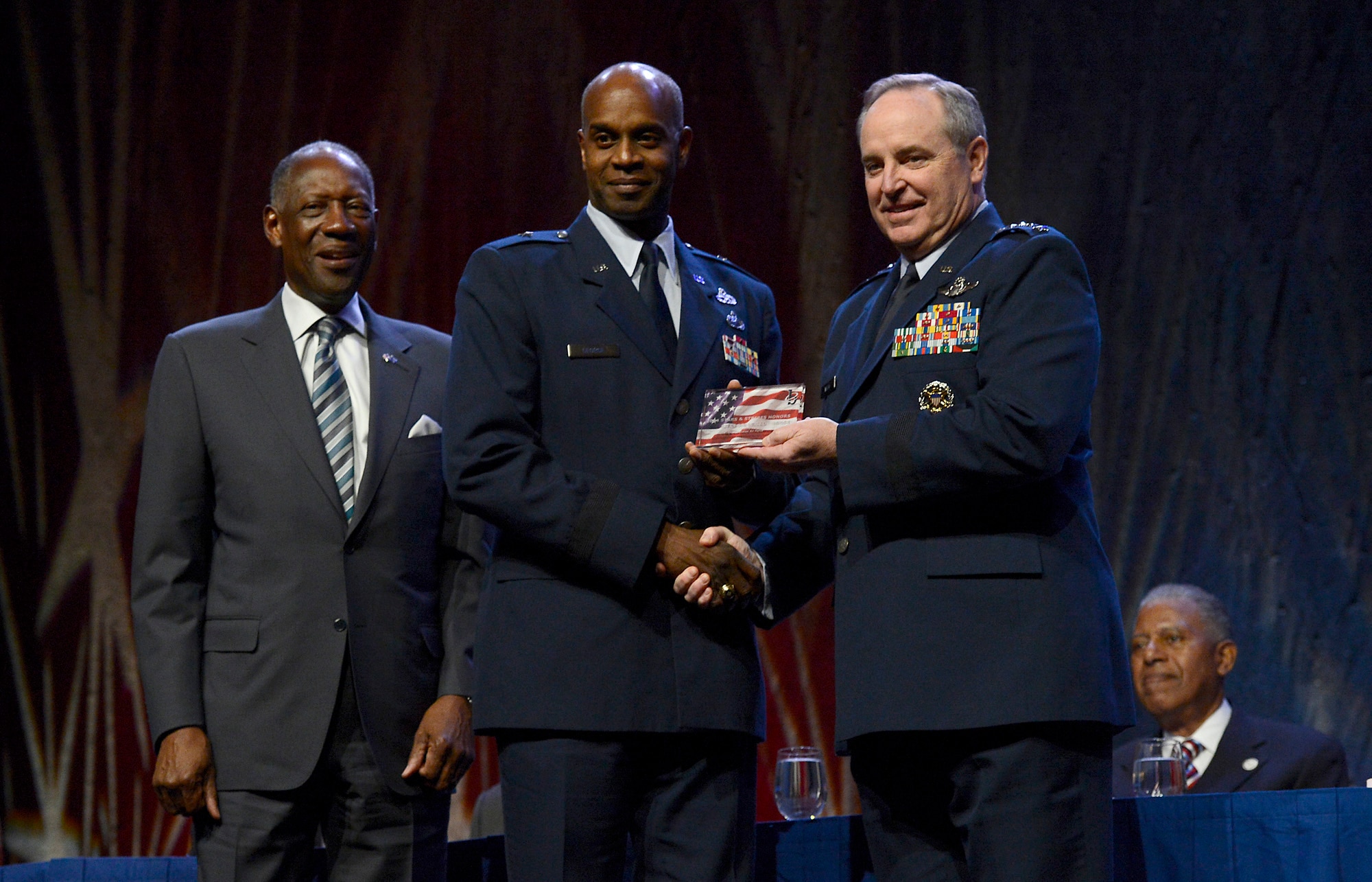 Air Force Chief of Staff Gen. Mark A. Welsh III and former Air Force Vice Chief of Staff Gen. Lester L. Lyles congratulate Brig. Gen. Cedric D. George on his receipt of the Black Engineer of the Year Award at the Ninth Annual Stars and Stripes dinner, Feb. 7, 2014, in Washington, D.C. George is the commander of the Warner Robins Air Logistics Complex, Robins Air Force Base, Ga. The dinner is held every year to honor engineers, both active and retired African American general officers and members of the senior executive service.  (U.S. Air Force photo/Scott M. Ash)