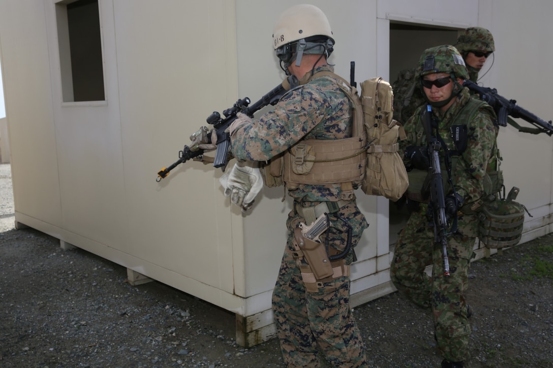 A U.S. Marine with 1st Reconnaissance Battalion, 1st Marine Division, and soldiers from the Japan Ground Self-Defense Force exit a building and move toward their next objective while conducting raid training during Exercise Iron Fist 2014 aboard Camp Pendleton Calif., Feb. 7, 2014. Iron Fist is an amphibious exercise that brings together Marines and sailors from the 15th Marine Expeditionary Unit, other I Marine Expeditionary Force units and soldiers from the JGSDF, to promote military interoperability and hone individual and small-unit skills through challenging, complex and realistic training.