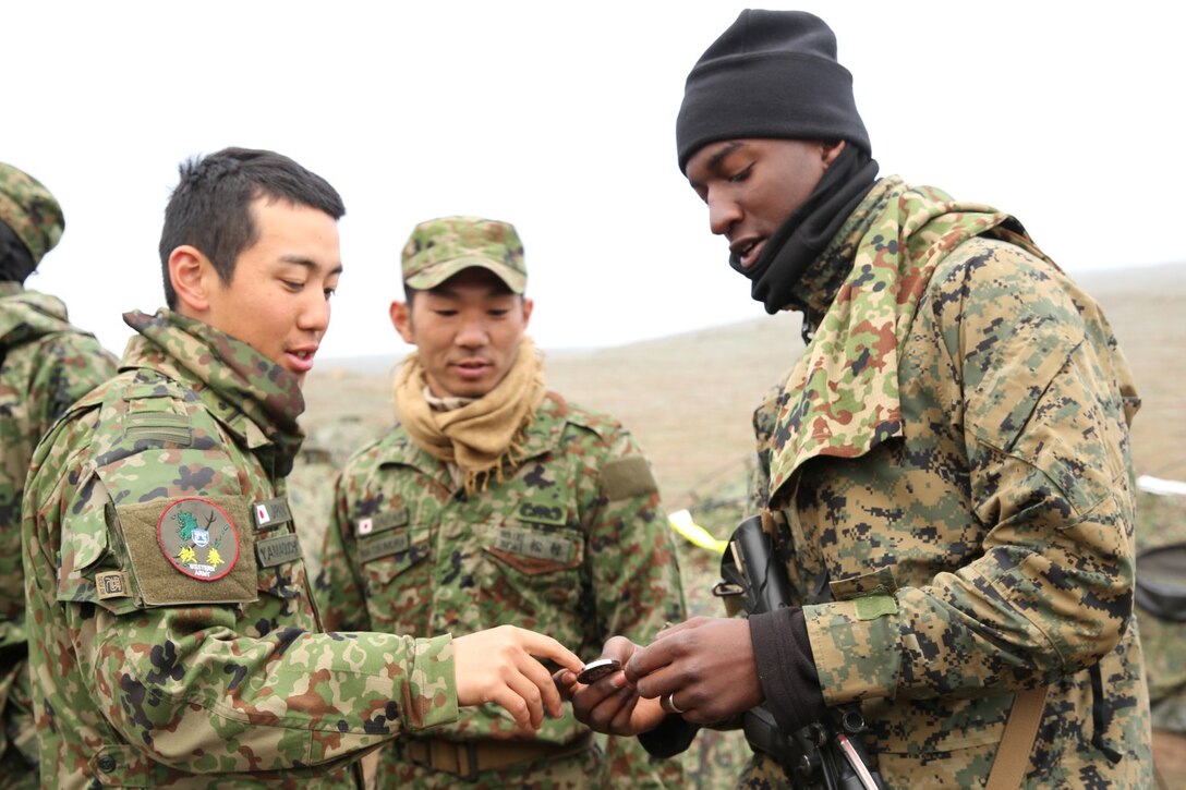 U.S. Marines with 1st Battalion, 1st Marine Regiment trade coins with soldiers from the Japan Ground Self-Defense Force during Exercise Iron Fist 2014 aboard Camp Pendleton, Calif., Feb. 9, 2014. Iron Fist 2014 is an amphibious exercise that brings together Marines and sailors from the 15th Marine Expeditionary Unit, other I Marine Expeditionary Force units, and soldiers from the JGSDF, to promote military interoperability and hone individual and small-unit skills through challenging, complex and realistic training. (U.S. Marine Corps photo by Lance Cpl. Anna K. Albrecht/Released)