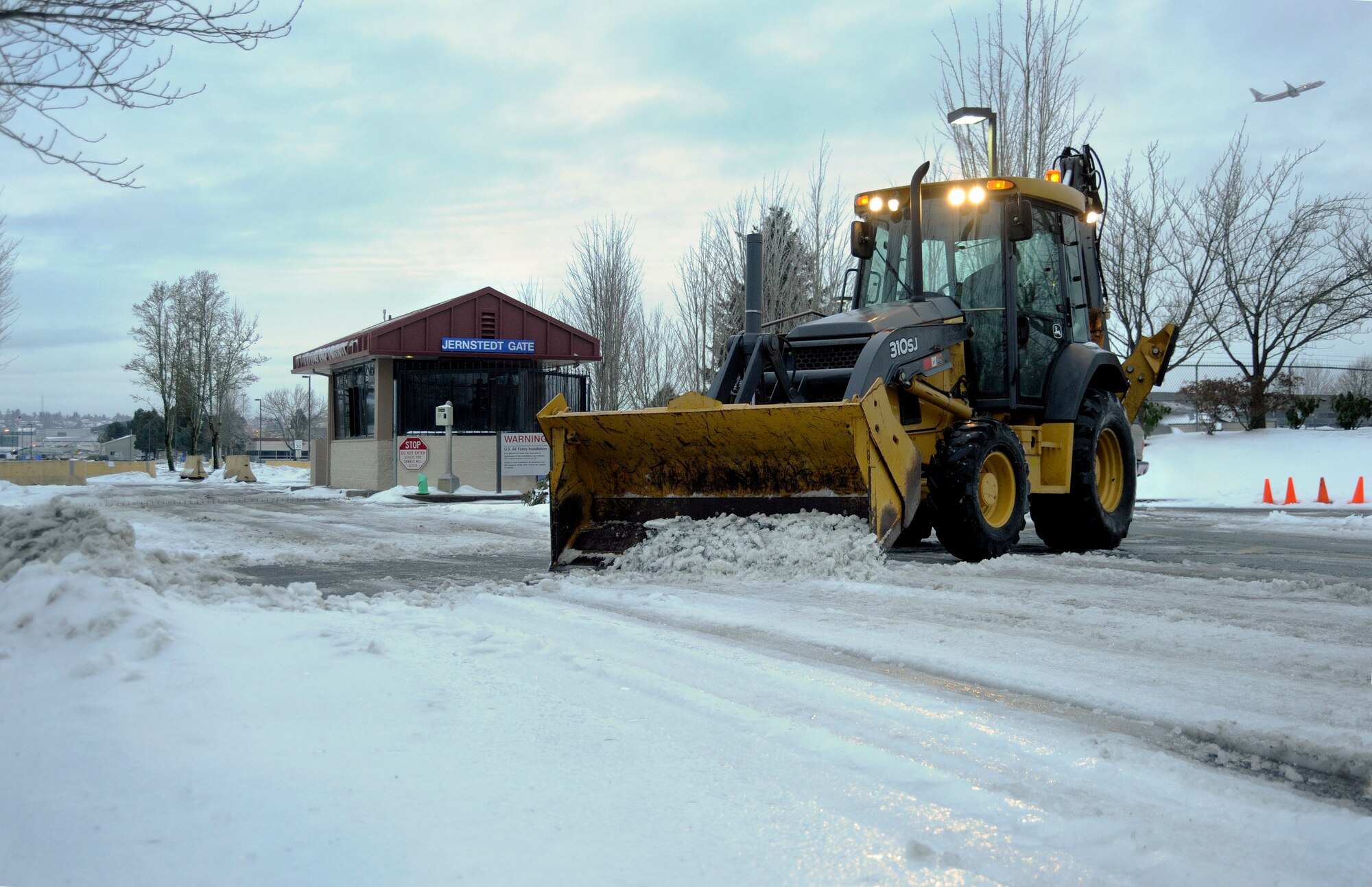 Oregon Air Guard Senior Airmen Andrew Wolf, 142nd Fighter Wing Civil Engineer Squadron, works to remove snow and ice from the main gate at the Portland Air National Guard Base, Ore., Feb. 10, 2014.  The February Unit Training Assembly was cancelled, but a small group from the CES worked over the weekend to keep the base running and the alert mission operational during the winter storm that hit the Pacific Northwest region. (Air National Guard photo by Tech. Sgt. John Hughel, 142nd Fighter Wing Public Affairs/Released)