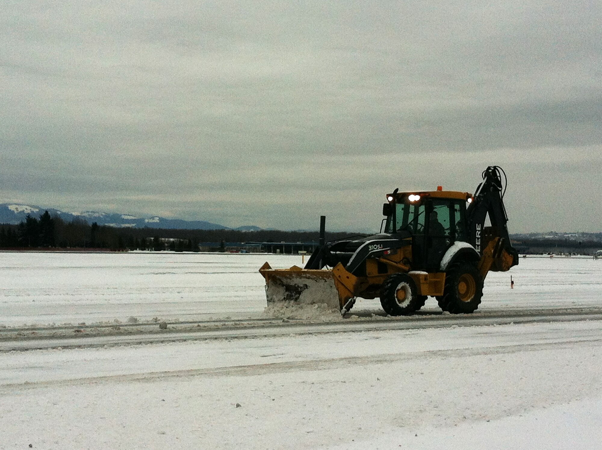 Airmen from the 142nd Fighter Wing Civil Engineer Squadron work to remove snow and ice from the Portland Air National Guard Base, Ore., Feb. 8, 2014.  The February Unit Training Assembly was cancelled, but a small group from the CES worked over the weekend to keep the base running and the alert mission operational during the winter storm that hit the Pacific Northwest region. (photo courtesy of Lt. Col. Jason Lay, 142nd Fighter Wing Civil Engineers)