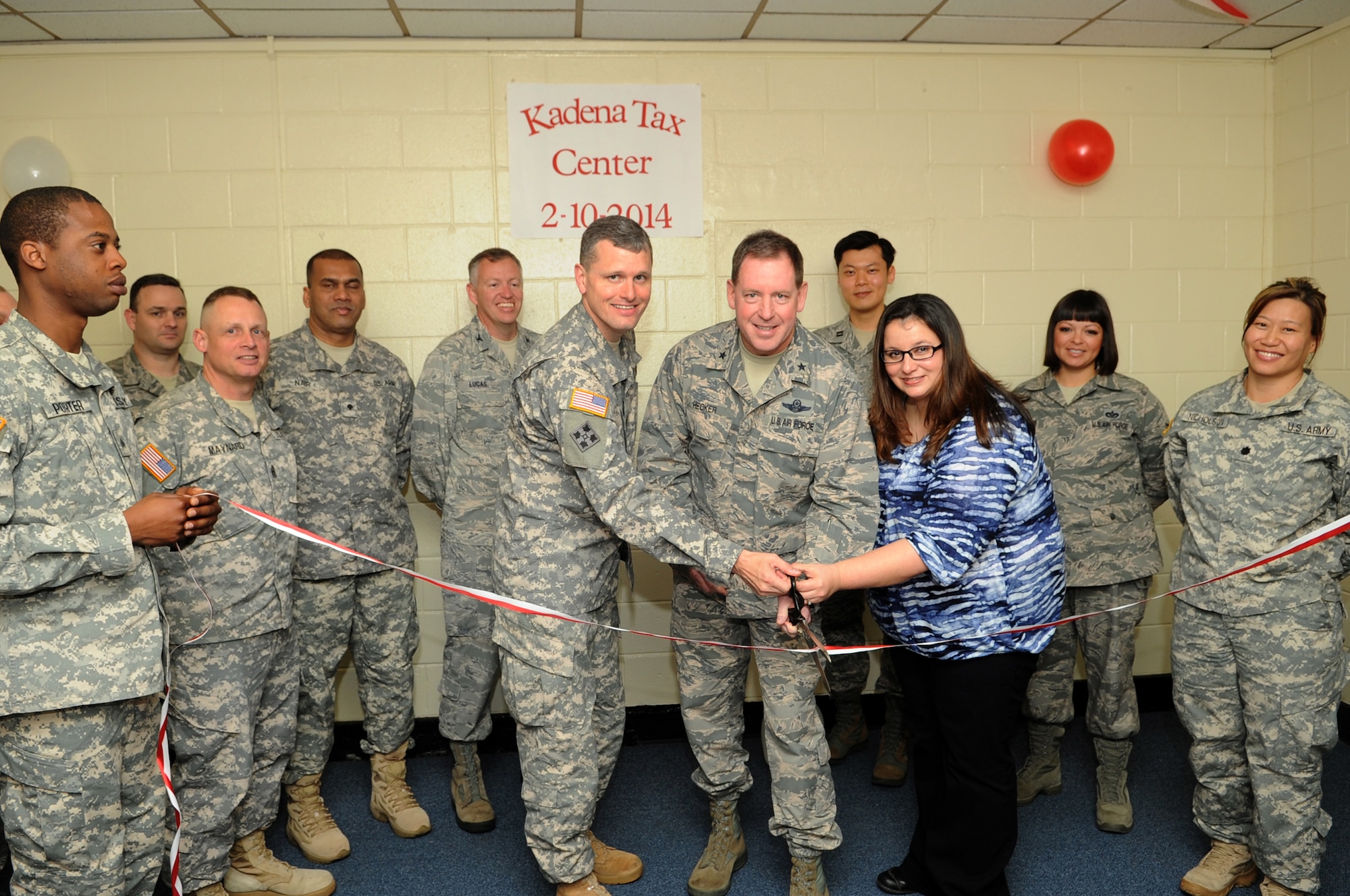 U.S. Army Lt. Col. Benjamin Ogden, 1st Battalion, 1st Air Defense Artillery Regiment battalion commander,  U.S. Air Force Brig. Gen. James Hecker, 18th Wing commander, and Christi Murphy, 18th Wing Legal Office chief of community legal services, cut a ribbon during the Kadena tax center official opening ceremony on Kadena Air Base, Japan, Feb. 10, 2014. The tax center, administered by the 18th Wing Legal Office and located in Bldg. 1460, is operated by more than 30 volunteer income tax assistance representatives who will provide free electronic tax filing to all Department of Defense ID card holders. (U.S. Air Force photo by Staff Sgt. Amber E. N. Jacobs)