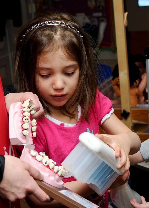Rebecca Arnold, preschool student in the base’s Child Development Center class 134, uses an oversized toothbrush to show her classmates how she brushes her teeth at Ellsworth Air Force Base, S.D., Feb. 6, 2014. To promote National Children’s Dental Health Month, Capt. Cory Peterson, 28th Medical Operations Squadron dentist, and his staff visited with children in the CDC and demonstrated how they can maintain healthy teeth and gums. (U.S. Air Force photo by Senior Airman Anania Tekurio/Released)