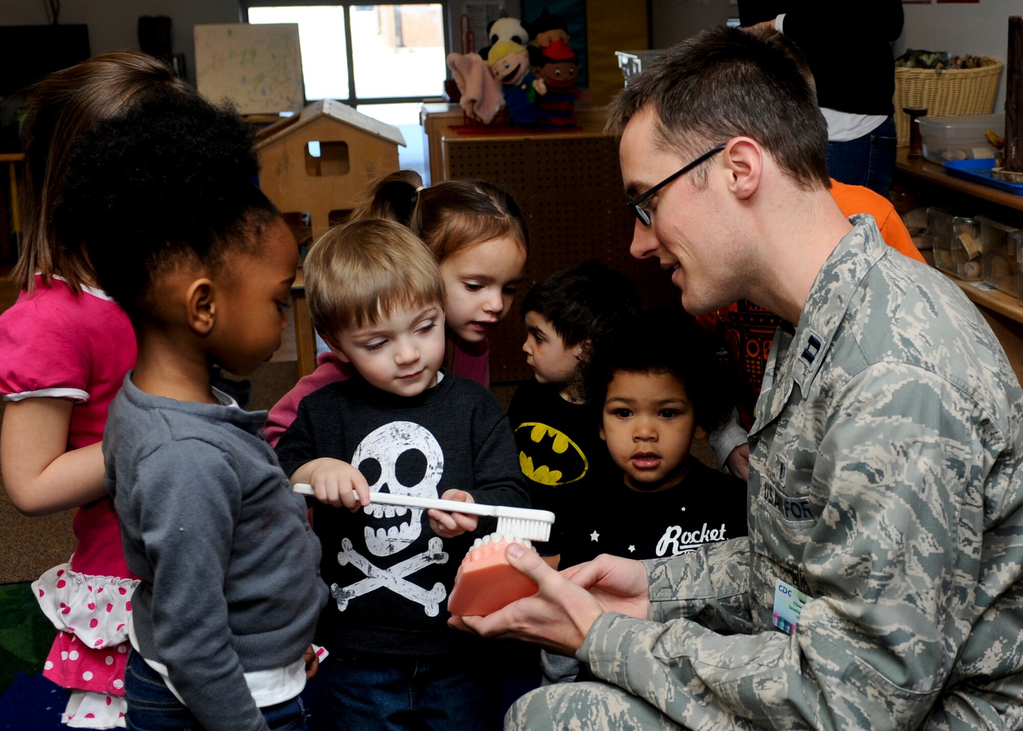 Capt. Cory Peterson, 28th Medical Operations Squadron dentist, teaches preschool students how to properly brush their teeth during a visit to the Child Development Center at Ellsworth Air Force Base, S.D., Feb. 6, 2014.  In commemoration of National Children’s Dental Health Month, Peterson and his staff visited with children in the CDC to emphasize the importance of keeping their teeth healthy. (U.S. Air Force photo by Senior Airman Anania Tekurio/Released)
