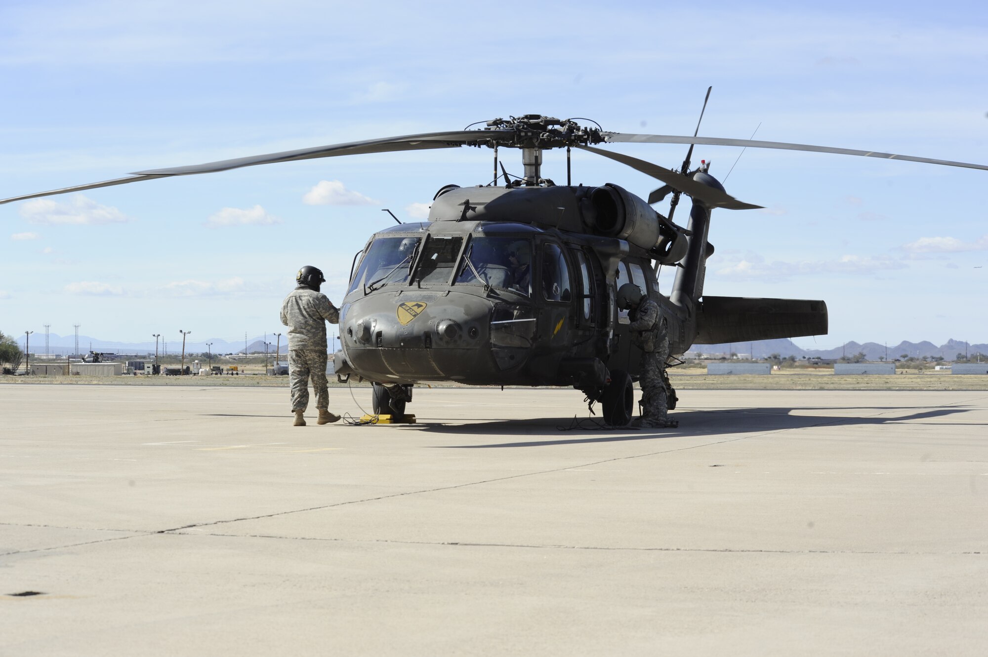 Members of the U.S. Army prepare a UH-60 Black Hawk for refueling after landing at Davis-Monthan Air Force Base, Ariz., Feb. 7, 2014. The aircraft and personnel, assigned to the 3-227th Assault Helicopter Battalion, 1st Air Calvary Brigade, 1st Cavalry Division out of Fort Hood, Texas, refueled at D-M before continuing to California where they will participate in a training exercise. (U.S. Air Force photo by Airman 1st Class Betty R. Chevalier/released)