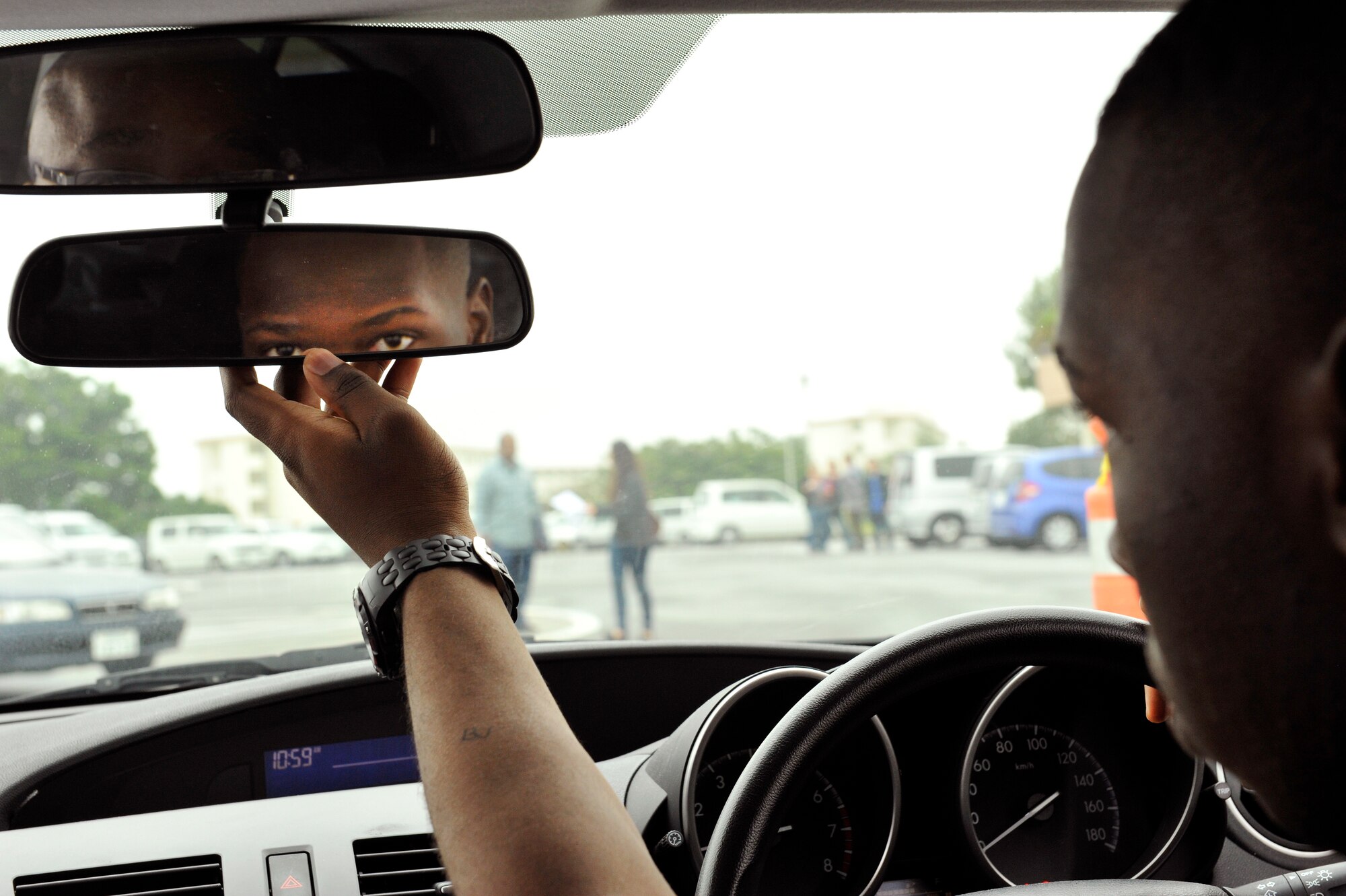 U.S. Air Force Airman 1st Class Branton Wingate, 18th Civil Engineer Group commander support staff administrator, adjusts a rear-view mirror during a Driver's Education course at the Schilling Community Center on Kadena Air Base, Japan, Feb. 7, 2014. The full course runs for four weeks (45 hours), including 39 hours of classroom instruction and six hours of behind-the-wheel instruction. The classroom instruction is held the first two weeks of the course and BTW instruction the second two weeks of the course. (U.S. Air Force photo by Naoto Anazawa)