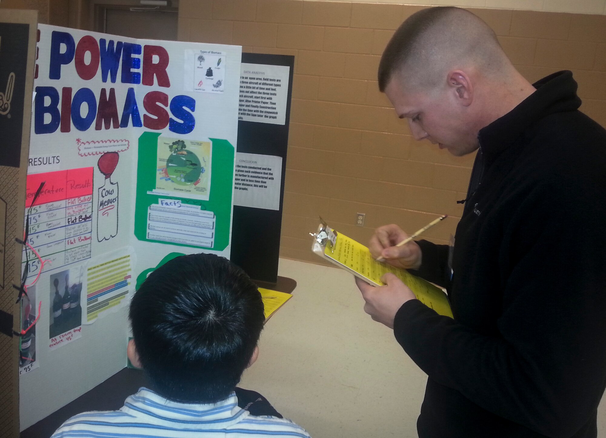 Airman 1st Class Matthew Booth, 47th Operations Support Squadron Aircrew Flight Equipment technician, evaluates a student’s science fair project at the Del Rio Civic Center Feb. 6, 2014. Several Laughlin members volunteered to judge the San Felipe Del Rio Consolidated Independent School District Regional Science Fair. (U.S. Air Force photo/Airman 1st Class Ariel D. Delgado)