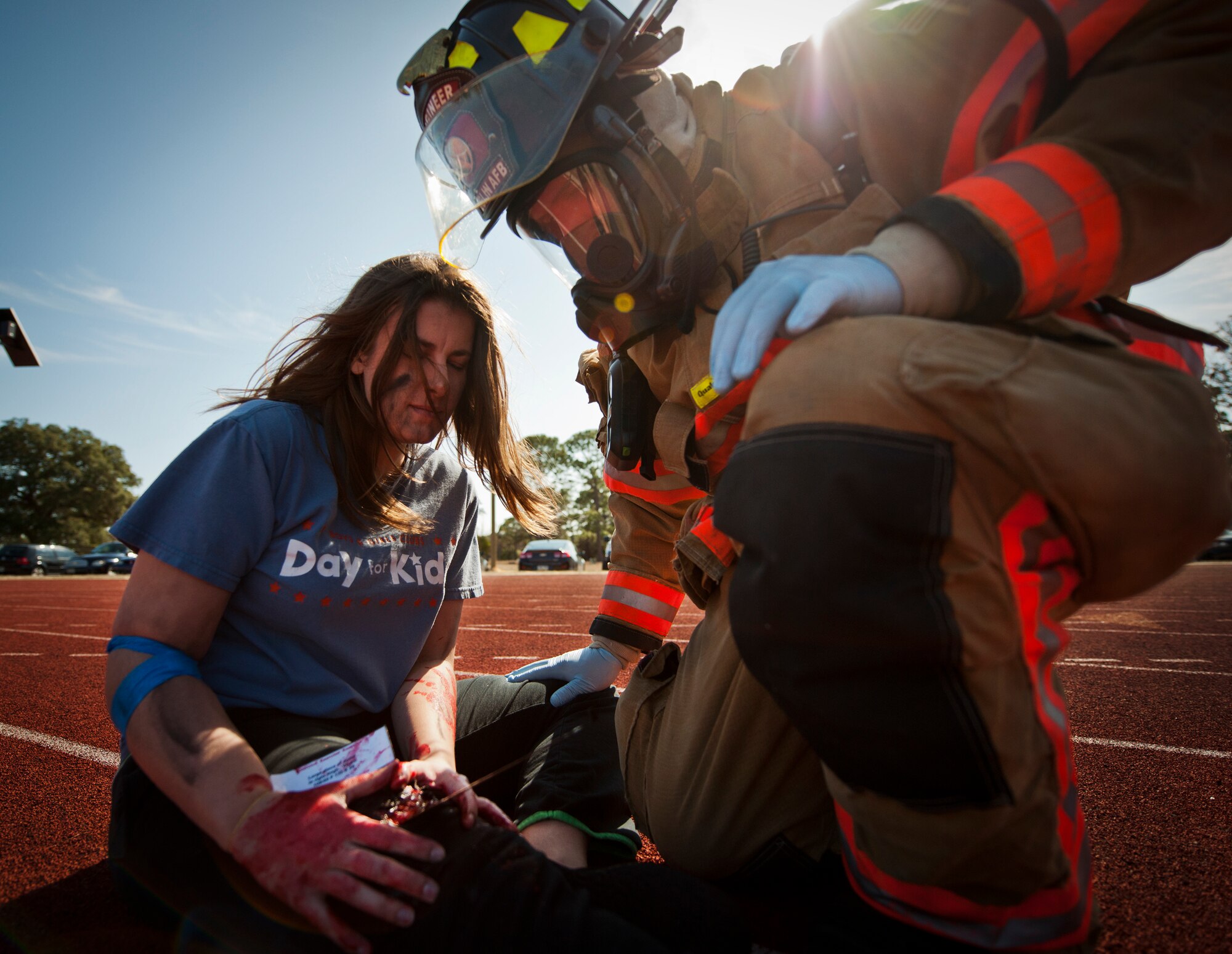 A 96th Test Wing firefighter evaluates a victim’s leg injury after a simulated bomb exploded injuring more than 30 people during a mass casualty exercise Feb. 5 at Eglin Air Force Base, Fla.  The simulated victims were moved to a safe area, decontaminated and then treated by 96th Medical Group personnel.  (U.S. Air Force photo/Samuel King Jr.)