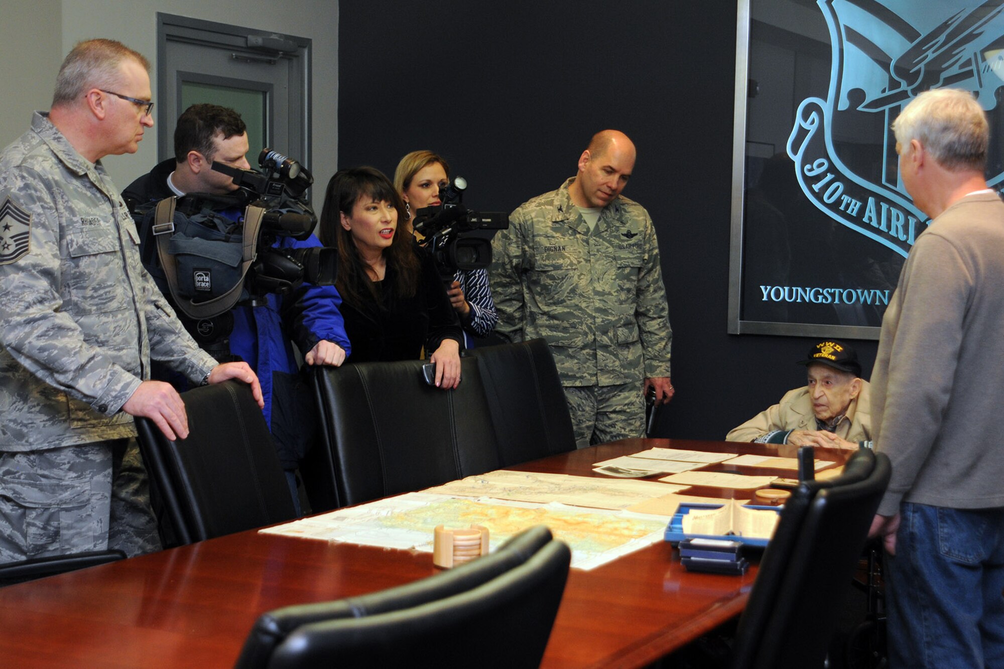 YOUNGSTOWN AIR RESERVE STATION, Ohio – Air Force Reserve 910th Airlift Wing Command Chief Master Sgt. Troy K. Rhoades; members of the Youngstown-area media; Col. James Dignan (center), 910th Airlift Wing commander and Mr. Edward Hitesman (seated), a World War II Army Air Corps veteran, listen as Jonathan Hitesman (right), talks about some of his father’s military memorabilia during a special tour here, Feb. 2, 2014. The 94-year-old Edward and his family, including son Jonathan, visited YARS at the request of Crossroads Hospice in Green, Ohio as part of the facility’s Gift of a Day program. The program is designed to ask terminal patients, “How do you envision your perfect day?” The hospice then strives to create that image and make it a special day for the patient and their family. The World War II veteran’s idea of a “perfect day” was to spend it at YARS and with the Citizen Airmen of the 910th Airlift Wing. U.S. Air Force photo by Senior Airman Rachel Kocin.