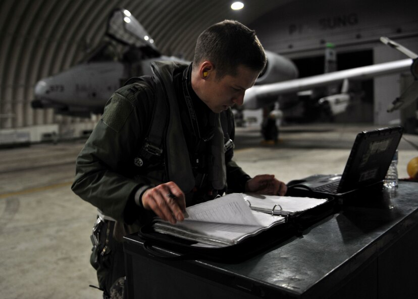 Capt. C.J. Anthony, 25th Fighter Squadron A-10 Thunderbolt II pilot, looks over a pre-flight inspection checklist during Beverly Midnight 14-02 at Osan Air Base, Republic of Korea, Feb. 10, 2014. Anthony and a crew chief from the 25th Aircraft Maintenance Unit ensured his A-10 was safe for flight prior to his departure. (U.S. Air Force photo/Senior Airman Siuta B. Ika)
