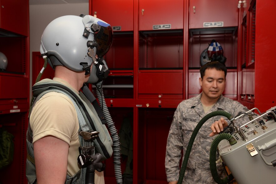 U.S. Air Force Staff Sergeant Ronald Armstrong (right), 20th Operations Support Squadron aircrew flight equipment craftsman assigned to the 77th Fighter Squadron at Shaw Air Force Base, S.C., conducts a pressure check on a CSU-13B/P anti G-suit worn by Airman 1st Class Kevin Maples, 20th OSS, aircrew flight equipment apprentice assigned to the 77th FS here, Feb. 5, 2014. The CSU-13B/P is used by fighter pilots to keep blood in the top half of their bodies during high speed midair maneuvers and needs to be pressure checked to ensure that there are no holes in the suit. (U.S. Air Force photo by Airman 1st Class Jonathan Bass/Released)