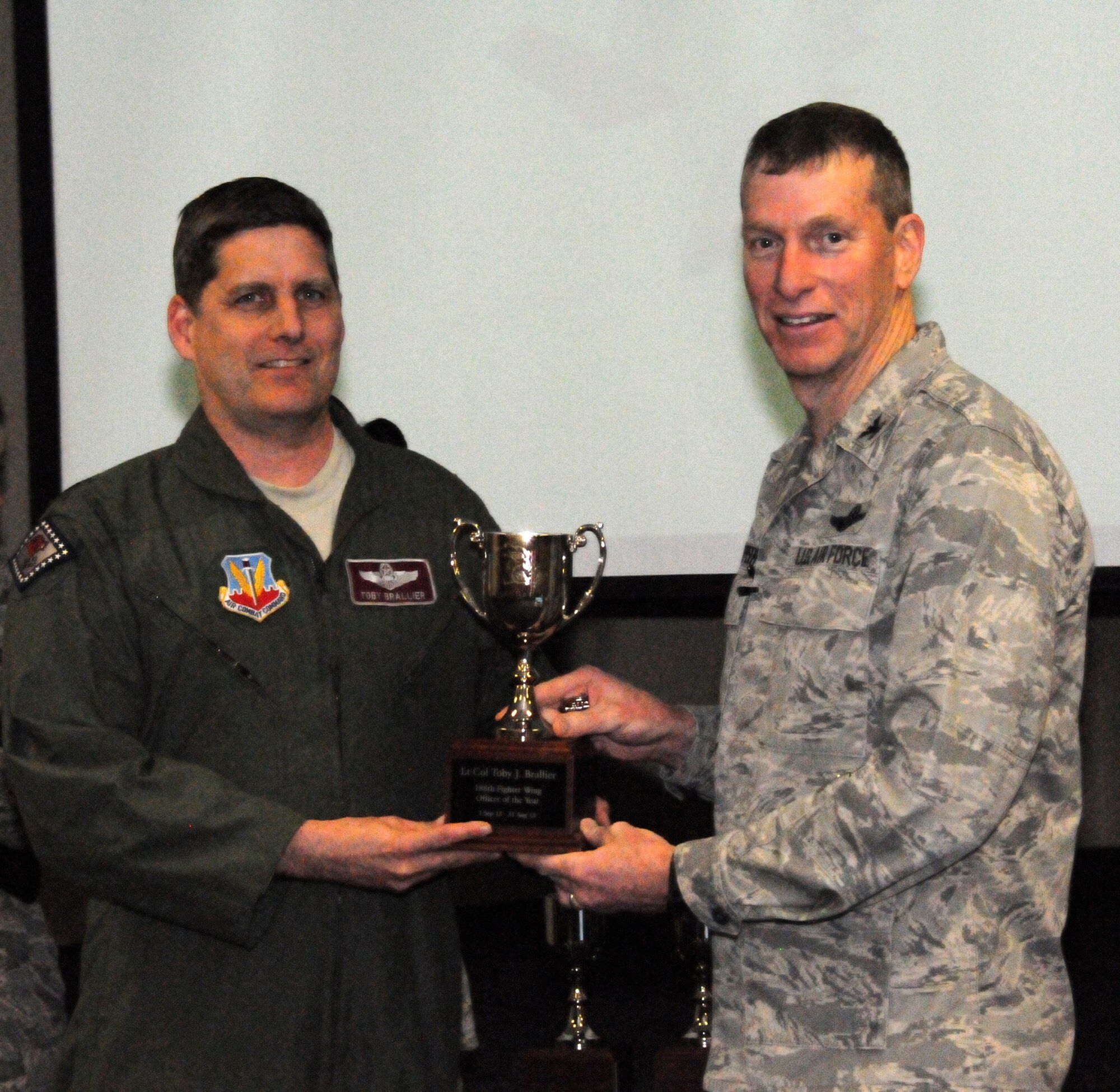 Col. Mark Anderson, 188th Fighter Wing commander, right, presents the 188th Outstanding Officer of the Year award to Lt. Col. Toby Brallier of the 184th Fighter Squadron during a commander’s call presentation Feb. 8, 2014. (U.S. Air National Guard photo by Airman 1st Class Cody Martin)