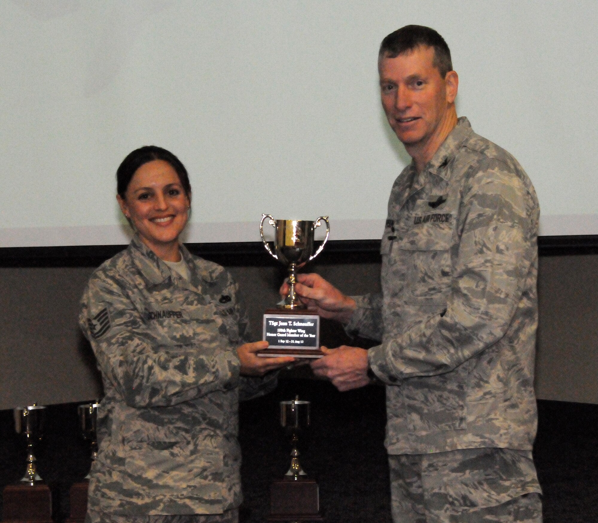 Col. Mark Anderson, 188th Fighter Wing commander, right, presents the 188th Outstanding Honor Guard Member of the Year award to Tech Sgt. Jean Schnauffer during a commander’s call presentation Feb. 8, 2014. (U.S. Air National Guard photo by Airman 1st Class Cody Martin)