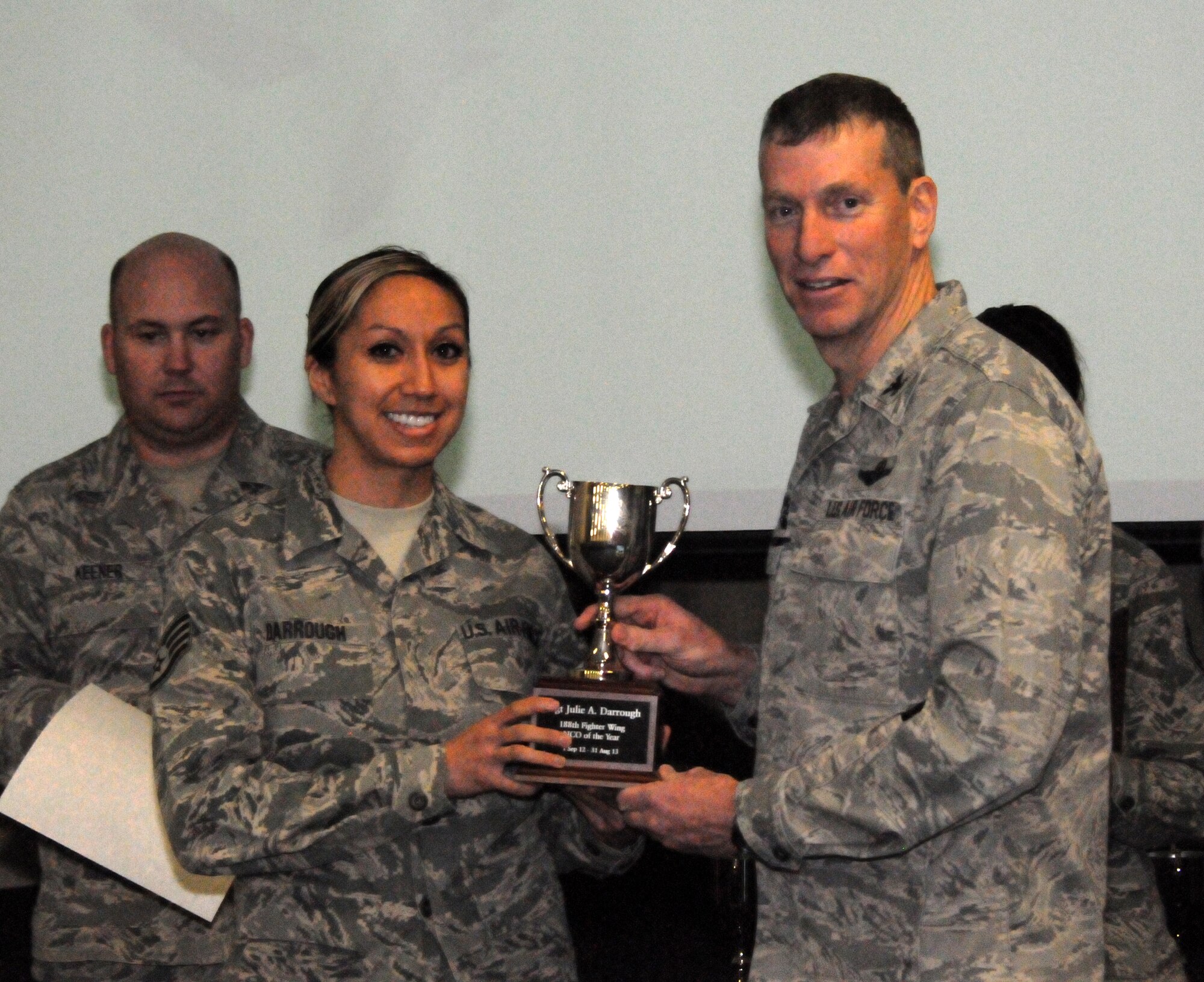Col. Mark Anderson, 188th Fighter Wing commander, right, presents the 188th Outstanding Noncommissioned Officer of the Year award to Staff Sgt. Julie Darrough of the 188th Communications Flight during a commander’s call presentation Feb. 8, 2014. (U.S. Air National Guard photo by Airman 1st Class Cody Martin)