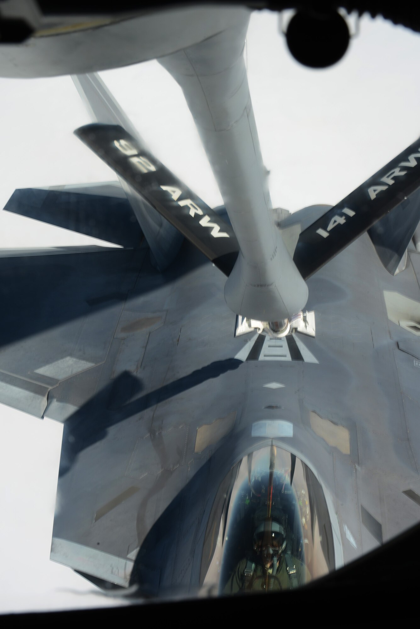 An F-22 Raptor from the 1st Fighter Wing, Joint Base Langley-Eustis, Va., is refueled from a KC-135 Stratotanker from the 93rd Air Refueling Squadron Fairchild Air Force Base, Wash., over the Nevada Test and Training Range during Red Flag 14-1 at Nellis AFB, Nev., Feb. 6, 2014. The introduction of low-visibility conditions presents aircrews with a number of challenges that test their ability to perform the mission at any time; day or night. (U.S. Air Force photo by Senior Airman Benjamin Sutton/Released) 