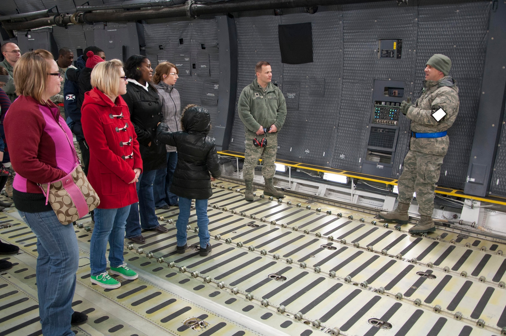 Staff Sgt. Mazimino Gonzalez Munoz, 436th Aircraft Maintenance Squadron aircraft hydraulic craftsman, far left, talks to members of the Key Spouse Program about the 436th AMXS’s involvement with the C-5M  Super Galaxy Feb. 6, 2014, on Dover Air Force Base, Del. Spouses toured the C-5M as well as the Aerial Port Squadron (U.S. Air Force photo/ Senior Airman Jared Duhon) 
