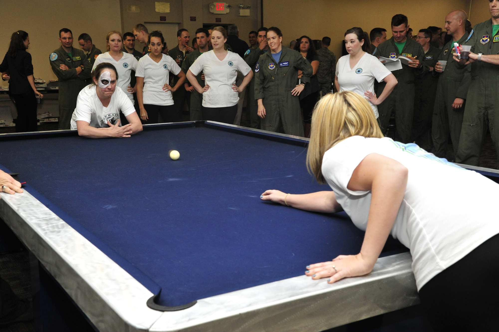 Team members watch as a Lady Top Hat hurls a ball with the aim of hitting team Peaches’ ball Jan. 31 at the women’s CRUD tournament in the Old Officer’s Club on Luke Air Force Base. The goal of the game is to stop or sink the opposing team’s ball until they have no lives left. (U.S. Air Force photo/Senior Airman Grace Lee)