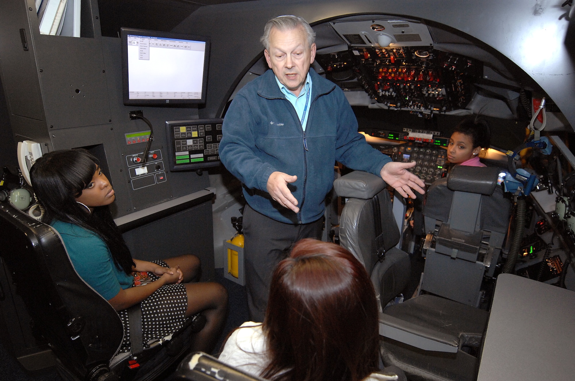 Michael Cook, an RC-135 instructor pilot from the 338th Combat Training Squadron at Offutt Air Force Base, Neb., explains the opportunities that are available in the Air Force to Bellevue East High School students. The students took turns flying an RC-135 simulator as part of the Offutt Flight Simulator Program that promotes education by inspiring students through experiences focused around science, technology, engineering and math. The program is sponsored by the Alfonza W. Davis chapter of Tuskegee Airmen Inc. (U.S. Air Force photo by Delanie Stafford/Released)