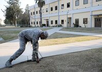 INCIRLIK AIR BASE, Turkey--Chief Master Sgt. Anthony Johnson, 39th Air Base Wing command chief, picks up cigarette buds in front of the wing headquarters building Feb. 7, 2014, at Incirlik Air Base.  Each unit is assigned an area of responsibility, in a team effort to better the appearance of the Incirlik community. This new initiative is designed to keep the base clean and get Airmen involved with taking pride in Incirlik. (U.S. Air Force photo by Staff Sgt. Veronica Pierce/Released) 