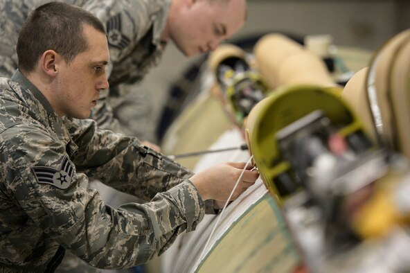 Senior Airman Jonathan Stariha, 576th Flight Test Squadron missile handling team technician, installs a cable raceway on an Intercontinental Ballistic Missile at Vandenberg Air Force Base, Calif., Feb. 3, 2014. The missile handling team transports and handles ICBMs and performs operational check-out actions of the Flight Destruct Ordnance Package on the Minuteman III boosters. (U.S. Air Force photo by Staff Sgt. Jonathan Snyder/RELEASED)