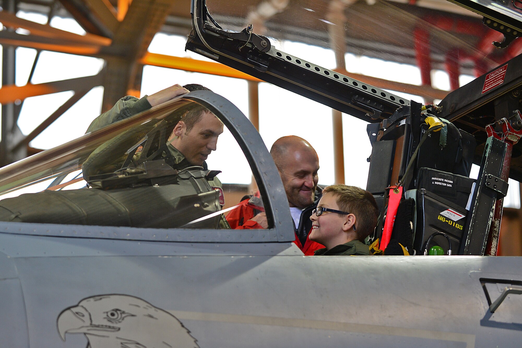 Maj. Jason Bianchi, 48th Operations Support Squadron chief of current operations, shows Harry McNeish, 9, the cockpit of an F-15C Eagle during a “Pilot for the Day” event at Royal Air Force Lakenheath, England, Feb. 5, 2014. The program started at RAF Lakenheath in March 2012, to assist children throughout local communities who are fighting life-threatening illness or conditions by providing a day of fun and allowing for a break from the routine doctor and hospital visits. (U.S. Air Force photo by Airman 1st Class Dana J. Butler/Released)